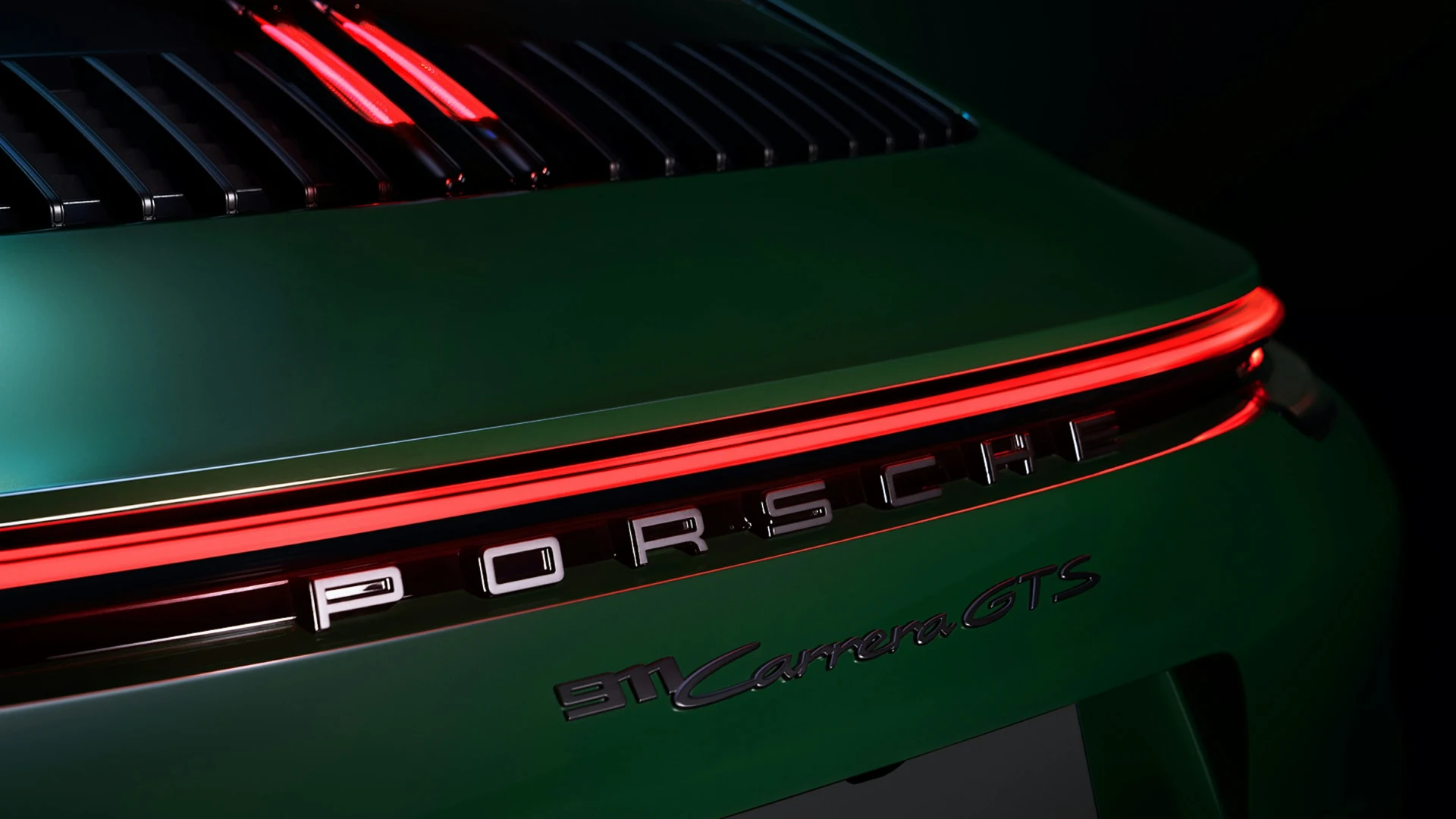 The red taillight and Porsche lettering against deep green paint